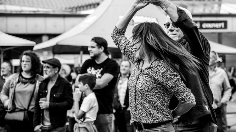 Un couple en train de danser le rock tandis que d'autres regardent le concert